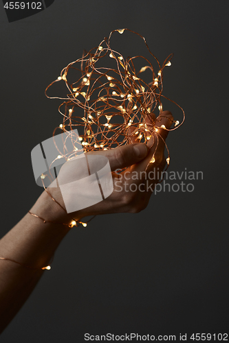 Image of bright christmas lights in woman\'s hands