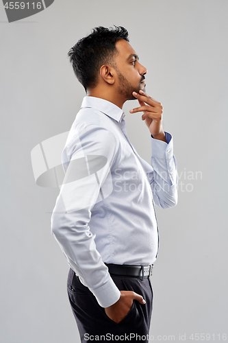 Image of indian businessman side view over grey background