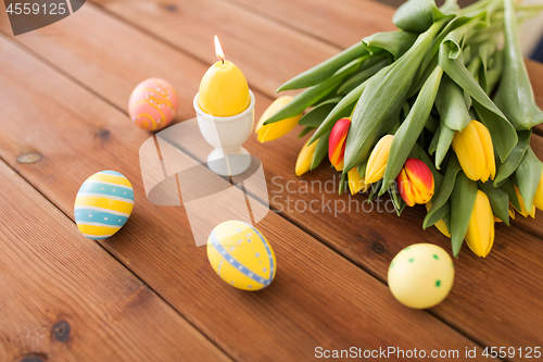 Image of candle in shape of easter egg and tulip flowers