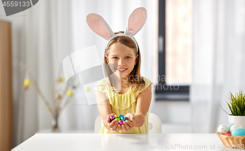 Image of happy girl with chocolate easter eggs at home