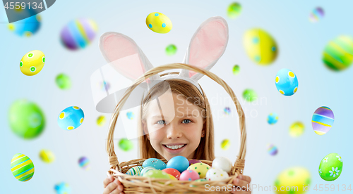 Image of happy girl with colored easter eggs in basket