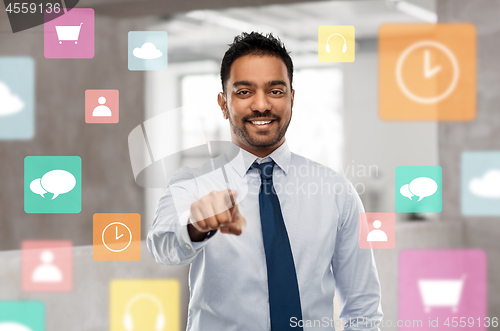 Image of businessman pointing to you or app icons at office