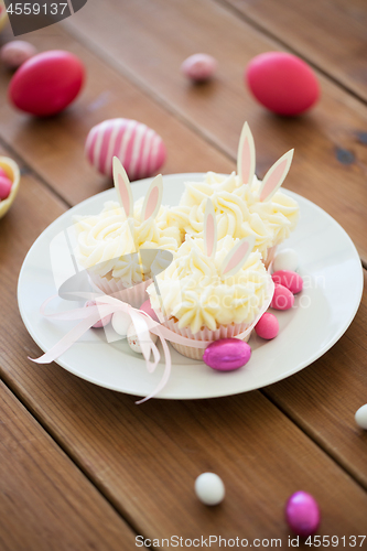 Image of cupcakes with easter eggs and candies on table