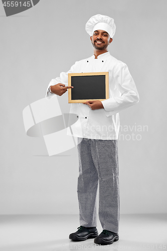 Image of happy male indian chef in toque with chalkboard