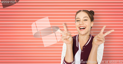 Image of happy smiling teenage girl showing peace sign