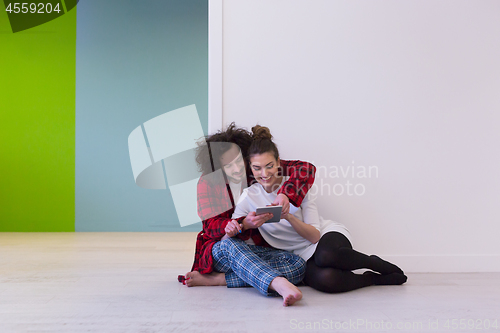 Image of Young Couple using digital tablet on the floor