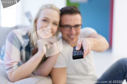 Image of Young couple on the sofa watching television