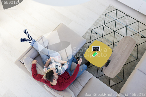 Image of Young couple on the sofa watching television