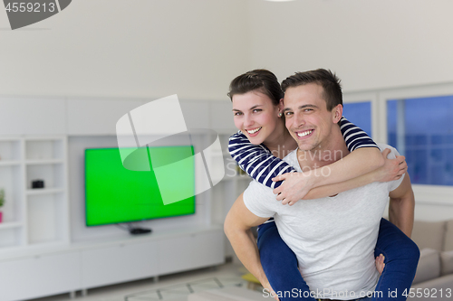 Image of handsome man piggybacking his girlfriend