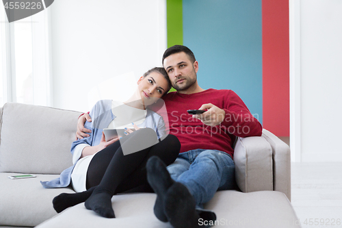 Image of Young couple on the sofa watching television