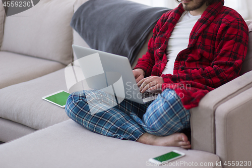 Image of man freelancer in bathrobe working from home