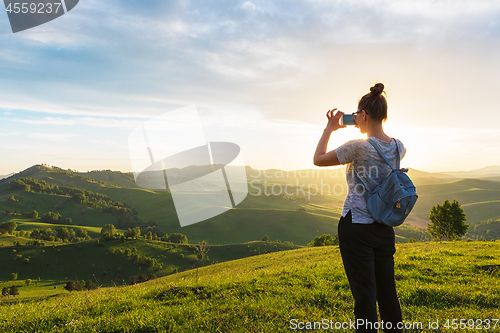 Image of Woman taking photo in mountain