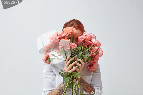 Image of Congratulation bouquet of roses in the gerl\'s hands with a tattoo on a white background. Trend color of the year 2019 Living Coral Pantone.