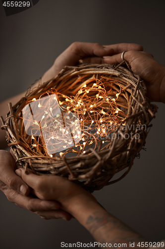 Image of Christmas wreath made of branches decorated with a Christmas lights