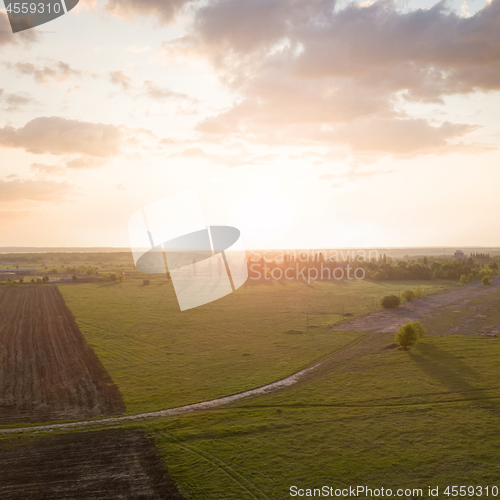 Image of Aerial view from the drone, a bird\'s eye view of abstract geometric forms of abandoned runway, forests and agricultural fields in the summer evening at sunset.