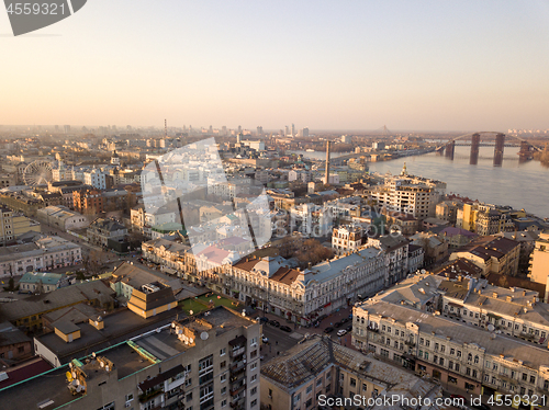 Image of The panoramic bird\'s eye view from drone to the central historical part of the city Kiev - the Podol district, the Dnieper River in Kiev, Ukraine at summer sunset.