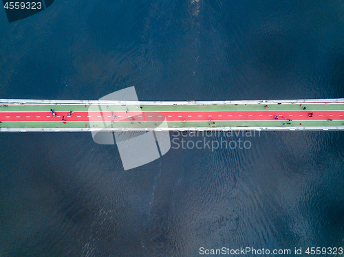 Image of People are walking on the pedestrian bridge in Kiev on a spring day. View from above