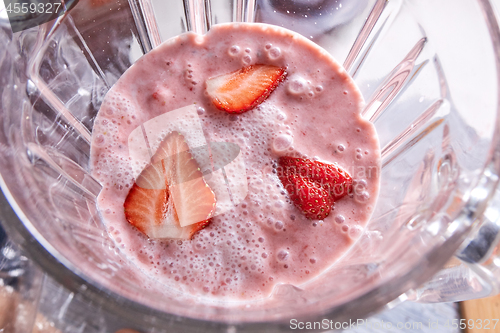 Image of Freshly prepared strawberry smoothie in a blender bowl. Healthy food. Top view