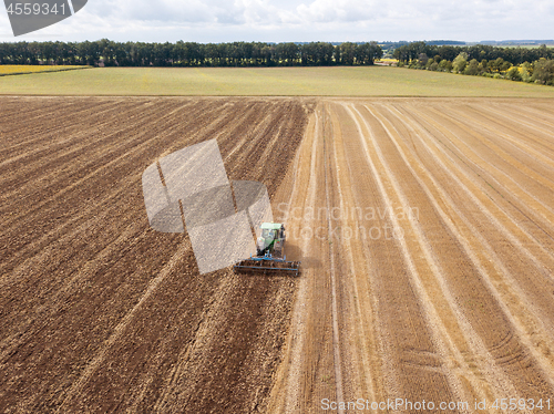 Image of Preparatory work for sowing crops, cultivation of the soil by a tractor after harvesting in the summer time.