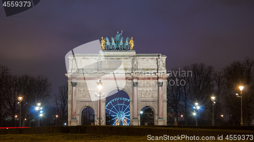 Image of Paris, France - August 04, 2006: Beautiful view of the Arc de Triomphe du Carrousel in the evening against the backdrop of street lamps.