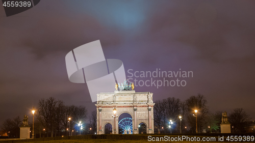 Image of Paris, France - August 04, 2006: Night panorama of the Triumphal arch du Carrousel on the background of the Ferris wheel and luminous street lamps