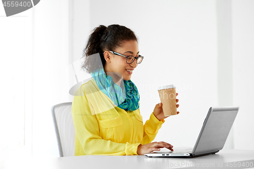 Image of creative woman with coffee and laptop at office