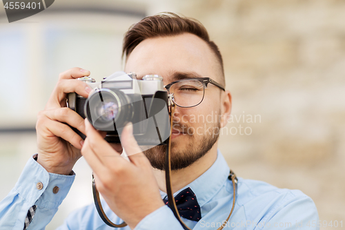 Image of photographer or hipster with film camera outdoors