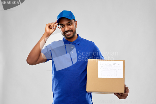 Image of happy indian delivery man with parcel box in blue