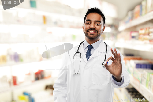 Image of smiling indian male doctor showing ok gesture