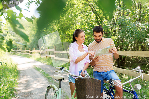 Image of couple with map and bicycles at country in summer