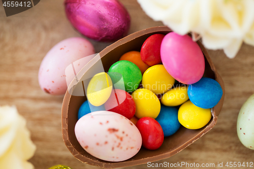 Image of chocolate easter egg and candy drops on table