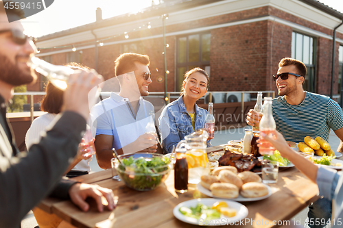 Image of happy friends with drinks or bbq party on rooftop