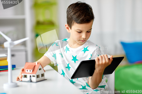 Image of boy with tablet, toy house and wind turbine