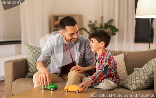 Image of father and son playing with toy cars at home