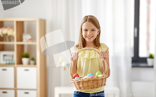 Image of happy girl with basket of easter eggs at home