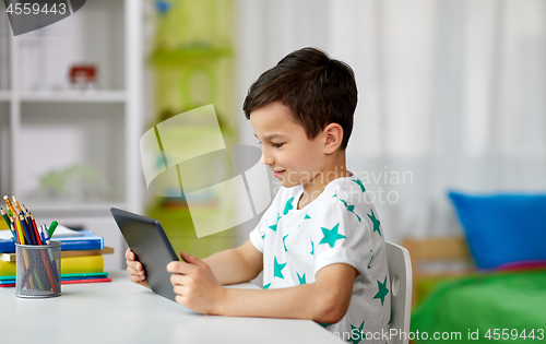 Image of student boy with tablet pc and notebook at home