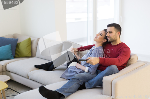 Image of Young couple on the sofa watching television