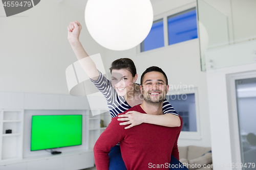 Image of handsome man piggybacking his girlfriend