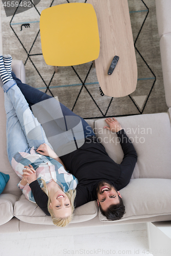 Image of Young couple on the sofa watching television top view