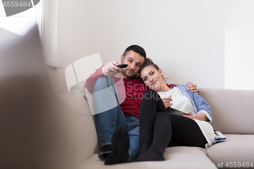 Image of Young couple on the sofa watching television