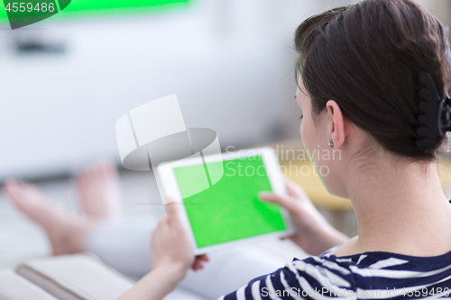 Image of woman on sofa using tablet computer