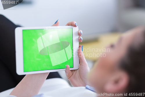 Image of woman on sofa using tablet computer