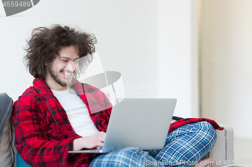 Image of man freelancer in bathrobe working from home