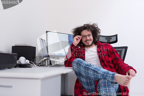 Image of graphic designer in bathrobe working at home