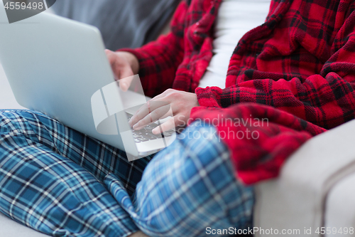 Image of man freelancer in bathrobe working from home