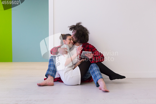 Image of Young Couple using digital tablet on the floor