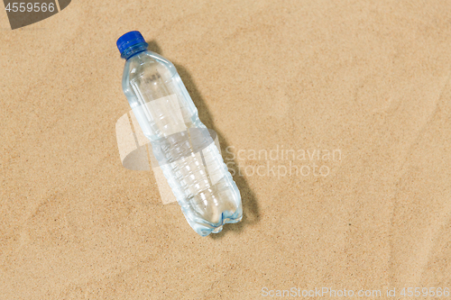 Image of bottle of water on beach sand