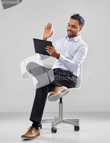 Image of indian businessman with tablet pc on office chair