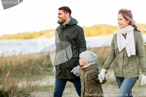 Image of happy family walking along autumn beach