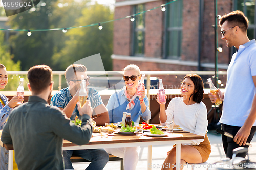 Image of happy friends with drinks or bbq party on rooftop